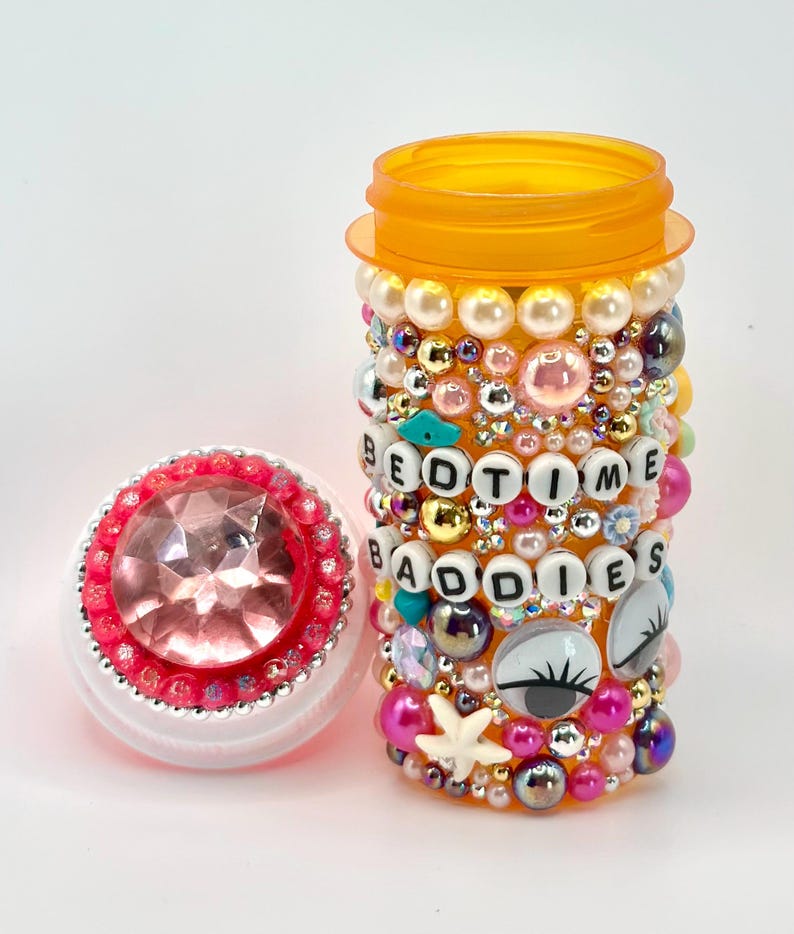 Bedazzled pill bottle covered in colorful beads and rhinestones, reading BEDTIME BADDIES