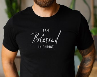 Puede incluir: Una camiseta negra con el texto "I am Blessed in Christ" en letras blancas.