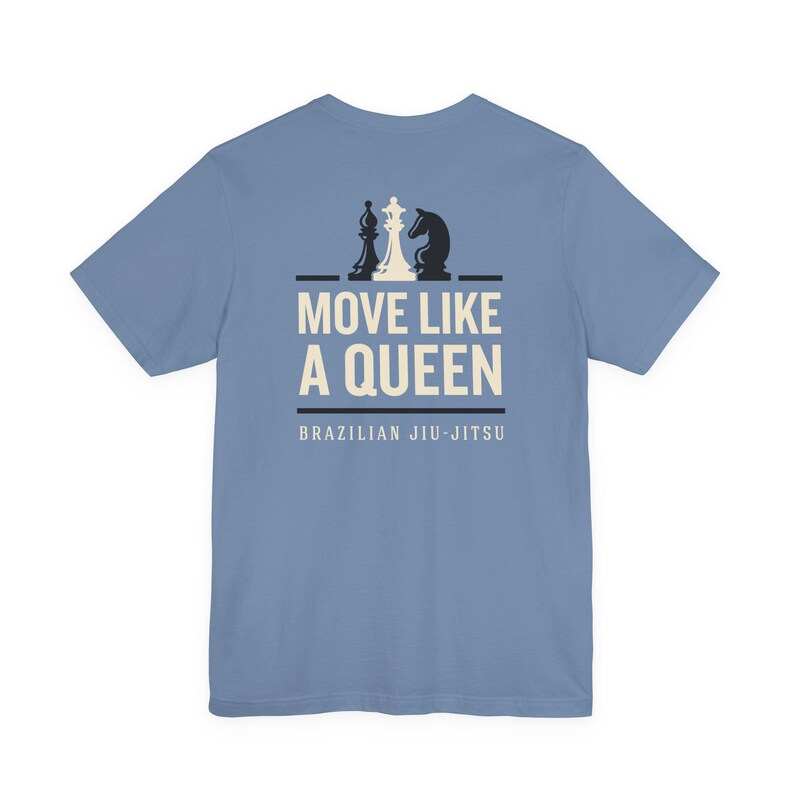 May include: A dusty blue short-sleeve t-shirt featuring a graphic on the back. The design includes a white chess queen flanked by two black chess pieces, with the text MOVE LIKE A QUEEN and BRAZILIAN JIU-JITSU printed in white below.