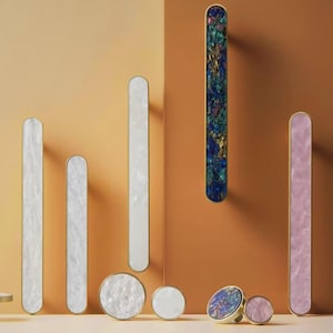 May include: Assortment of decorative cabinet hardware in various colors and patterns.  The hardware includes knobs and pulls in a variety of shapes and sizes.  The hardware is made of metal and features a polished finish.