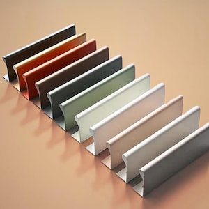 May include: A set of ten cabinet door pulls in various colours, including black, brown, red, green, white, and grey. The pulls are made of metal and have a sleek, modern design.