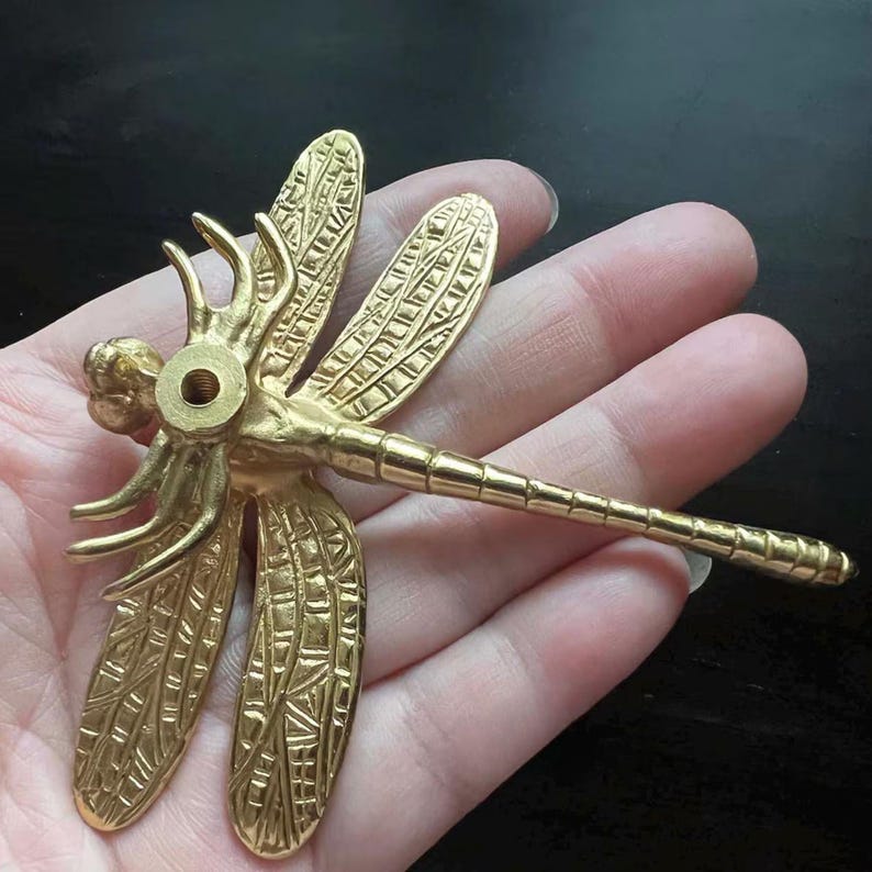 Puede incluir: Pomo de puerta de metal dorado en forma de lib&eacute;lula con detalles intrincados en las alas. El pomo tiene un agujero para un tornillo.