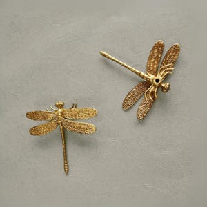 Puede incluir: Dos piezas de decoraci&oacute;n de pared de lib&eacute;lula de metal dorado. Las lib&eacute;lulas tienen detalles intrincados y son una gran adici&oacute;n a cualquier decoraci&oacute;n del hogar.