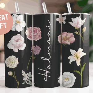 May include: Three stainless steel tumblers with black backgrounds and floral designs. The tumblers have white text that reads "Halmoni", "Great Gift", and a floral design.