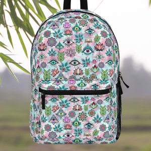 May include: A blue and pink backpack with a colorful pattern of eyes, flowers, and leaves. The backpack has a large main compartment and a smaller front pocket.
