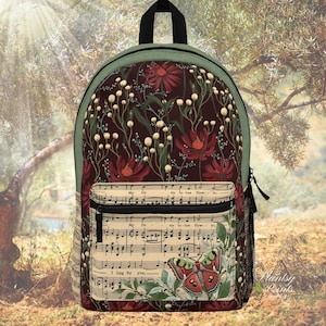 May include: A green and brown backpack with a floral pattern and a musical note design. The backpack has a zippered pocket on the front and a mesh pocket on the side. The text "I long for you..." is printed on the front of the backpack.
