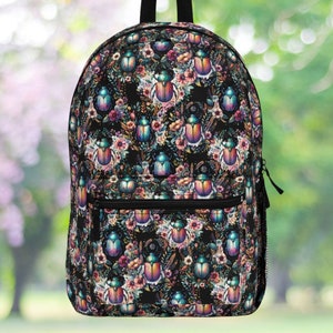 May include: A black backpack with a colorful floral and beetle pattern. The beetles are iridescent green, blue, and purple. The flowers are pink, yellow, and white.