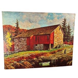 May include: A vintage painting depicts a red barn with a stone foundation and a brown roof, set against a backdrop of autumn foliage. A small boat floats on the water near the barn, and two figures are visible on the shore.