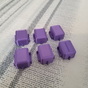 May include: Seven purple plastic boxes with a textured surface. The boxes are all the same size and shape.