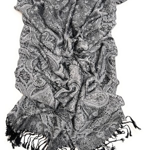 May include: A black and white paisley patterned scarf with black fringe.