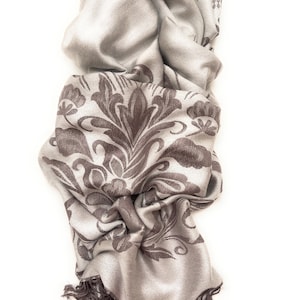 May include: A grey and brown patterned scarf with fringe. The scarf is made of a soft, silky material and has a delicate floral design.