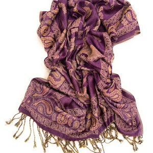 May include: A purple and gold paisley patterned scarf with fringed edges.
