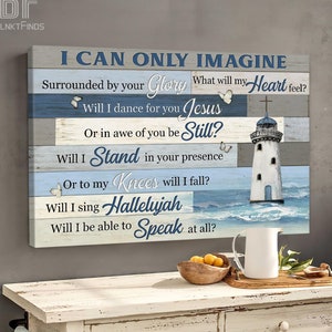 May include: A blue and white canvas print with a lighthouse and the text "I can only imagine" and lyrics from the song "I Can Only Imagine" by MercyMe. The print is on a wooden surface with a white pitcher and a bowl of oranges.