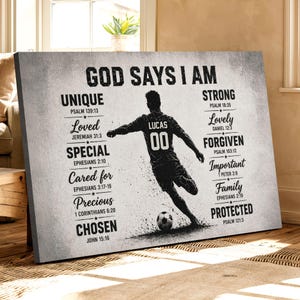 May include: A canvas print with the text "GOD SAYS I AM" and inspirational words like "Unique" and "Strong." A soccer player silhouette is featured, with the name "LUCAS" and the number "00" on the jersey. The print is in black and white.