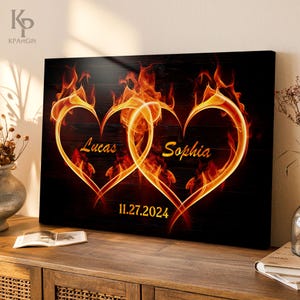 May include: Two intertwined hearts made of flames on a black wooden background. The hearts are labeled "Lucas" and "Sophia" with the date "11.27.2024" below.