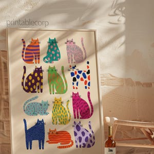 Puede incluir: Una impresi&oacute;n art&iacute;stica enmarcada con ilustraciones de gatos coloridos y estilizados. Cada gato es de un color y patr&oacute;n diferente, incluyendo rayas, lunares y tonos s&oacute;lidos. La impresi&oacute;n se muestra en una pared con un fondo neutro, y el texto "printablecorp" es visible.