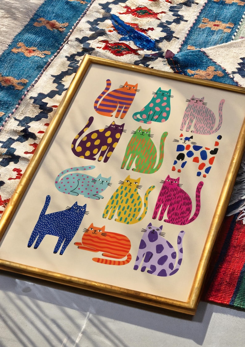 Puede incluir: Una impresi&oacute;n art&iacute;stica enmarcada con ilustraciones de gatos coloridos y estampados. Cada gato presenta patrones &uacute;nicos, como rayas y lunares, en varios colores. La obra de arte est&aacute; enmarcada en un marco dorado y sobre un fondo crema. Los gatos est&aacute;n en varias poses.