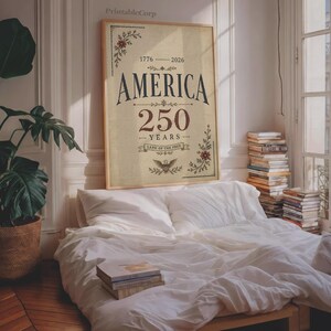 Pu&ograve; includere: Una stampa incorniciata con la scritta "AMERICA 250 YEARS" in stile vintage. La stampa &egrave; in una cornice di legno ed &egrave; esposta sopra un letto con lenzuola bianche. La stampa include gli anni 1776-2026 e le parole "Land of the Free".