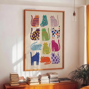 Puede incluir: Una impresi&oacute;n art&iacute;stica enmarcada con ilustraciones de gatos coloridos y estampados. Los gatos est&aacute;n representados en varias poses y colores, incluyendo naranja, azul, verde y morado, con rayas, lunares y otros dise&ntilde;os. La impresi&oacute;n se muestra en una pared.