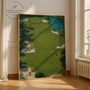 Puede incluir: Una impresión enmarcada de un campo de golf con una calle verde, trampas de arena y una masa de agua azul. Pequeñas figuras de golfistas están dispersas por el campo. La impresión tiene un marco dorado y el texto "The Printable Design Studio".