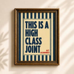 Könnte beinhalten: Ein gerahmter Kunstdruck mit vertikalen marineblauen und cremefarbenen Streifen. Der mittlere Text lautet THIS IS A HIGH CLASS JOINT in großen marineblauen Buchstaben, mit dem kleineren roten Text ACT ACCORDINGLY in der unteren rechten Ecke.