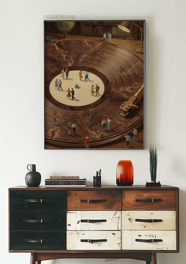 May include: A framed artwork depicts a vinyl record with miniature figures dancing on its surface. The record player's arm and needle are visible. The artwork is displayed above a wooden dresser with various drawers and decorative items.