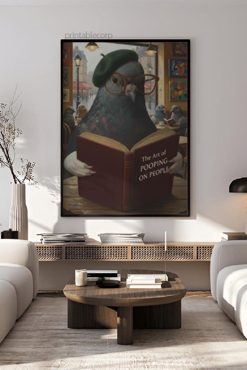 May include: A framed art print featuring a pigeon wearing a beret and glasses, reading a book titled "The Art of Pooping on People." The artwork has a humorous theme and is set in a cafe with other pigeons.