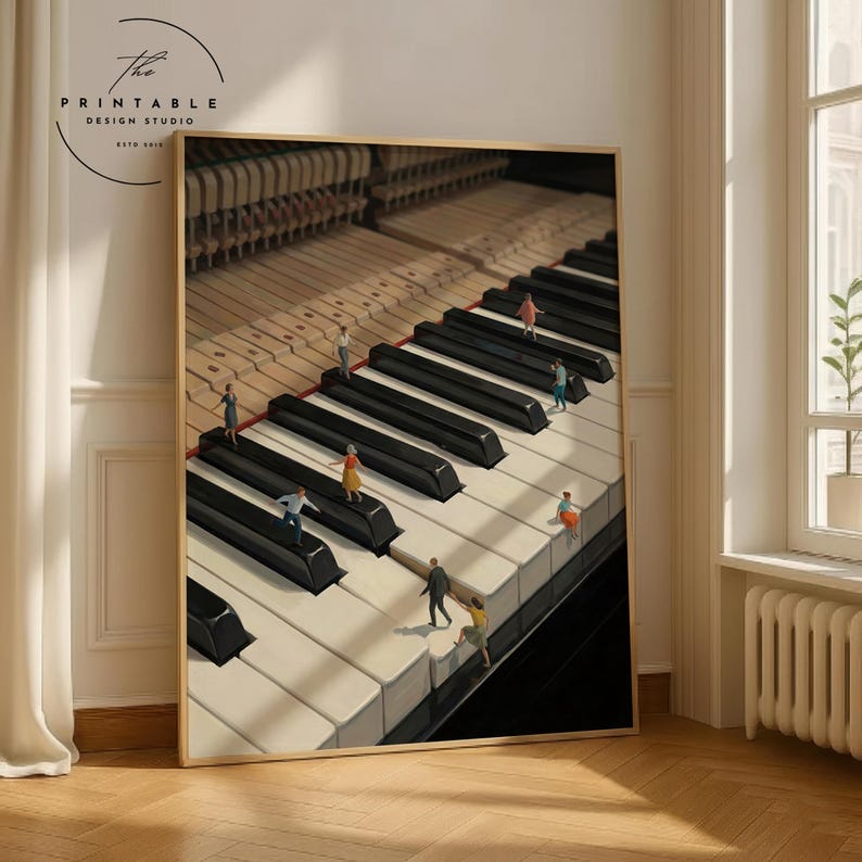 May include: A framed print featuring a piano keyboard with miniature figures walking on the keys. The black and white keys are in sharp focus, with the piano's internal mechanisms visible in the background. The print has a wooden frame and the text "The Printable Design Studio" in the upper left corner.