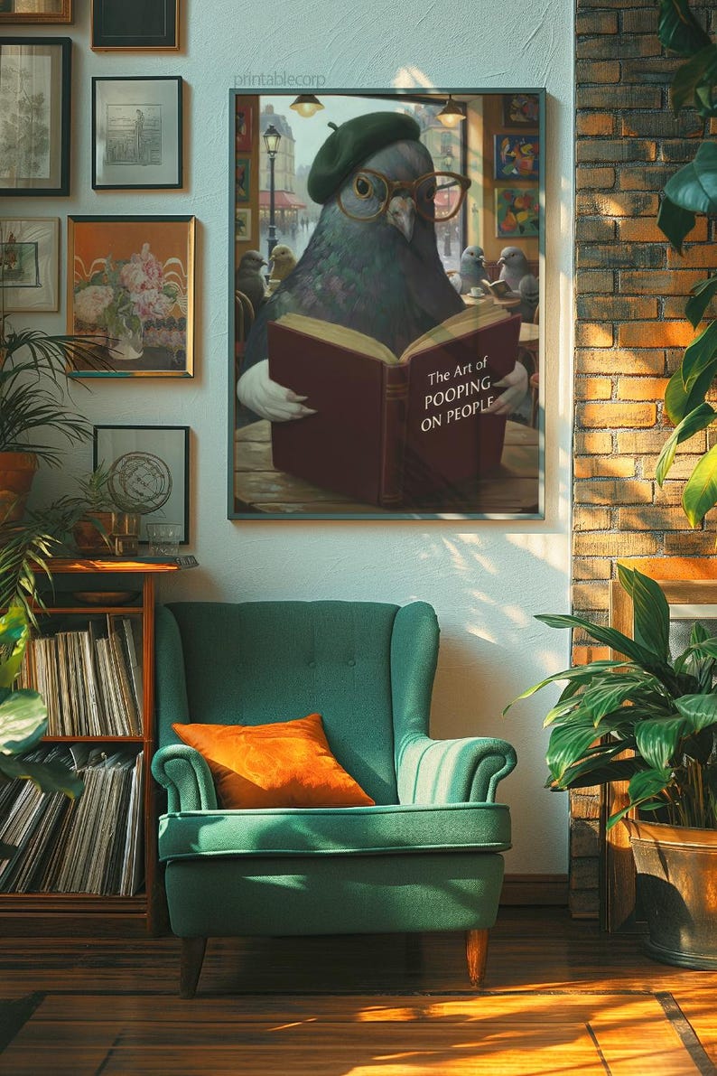 May include: A framed print featuring a pigeon wearing glasses and a beret, reading a book titled "The Art of Pooping on People." The artwork is displayed above a green armchair with an orange pillow. The room has a brick wall and wooden floor.