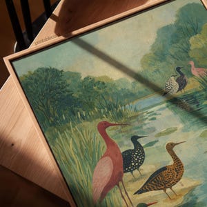 Puede incluir: Una impresi&oacute;n art&iacute;stica enmarcada que presenta un paisaje sereno con varias especies de aves cerca de una masa de agua. La obra de arte muestra una paleta de verdes, azules y rosas, con el texto "printable.com" visible en el marco.