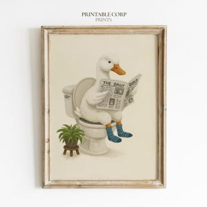 Puede incluir: Una lámina artística enmarcada que muestra a un pato blanco sentado en un inodoro blanco, con calcetines de rayas azules y leyendo un periódico titulado The Daily Quack. Una pequeña planta verde en un taburete de madera se sitúa al lado.