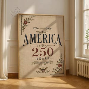 Pu&ograve; includere: Opera d'arte incorniciata con la parola "AMERICA" in blu navy, che celebra 250 anni. L'opera include gli anni 1776-2026, le parole "250 YEARS" e "LAND OF THE FREE", e dettagli floreali agli angoli. L'opera &egrave; in una cornice di legno.