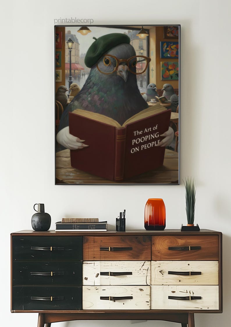 May include: A framed print featuring a pigeon wearing glasses and a beret, reading a book titled "The Art of Pooping on People." The artwork is displayed above a wooden dresser with various decorative items.