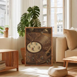 May include: A framed artwork depicts a vintage record player with miniature figures dancing on the record's surface. The artwork has a warm color palette with a wooden frame. The scene is set in a room with natural light and a large green plant.