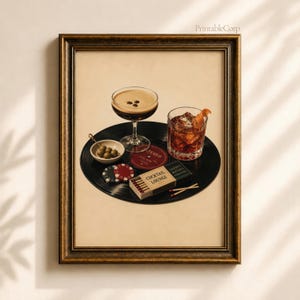 Könnte beinhalten: Ein gerahmter Wandkunstdruck mit einer schwarzen Schallplatte als Unterlage für ein Martiniglas mit Kaffeebohnen, ein Whiskyglas mit Orangenschale, eine kleine Schale mit grünen Oliven, Pokerchips und eine Schachtel mit Cocktail Lounge.