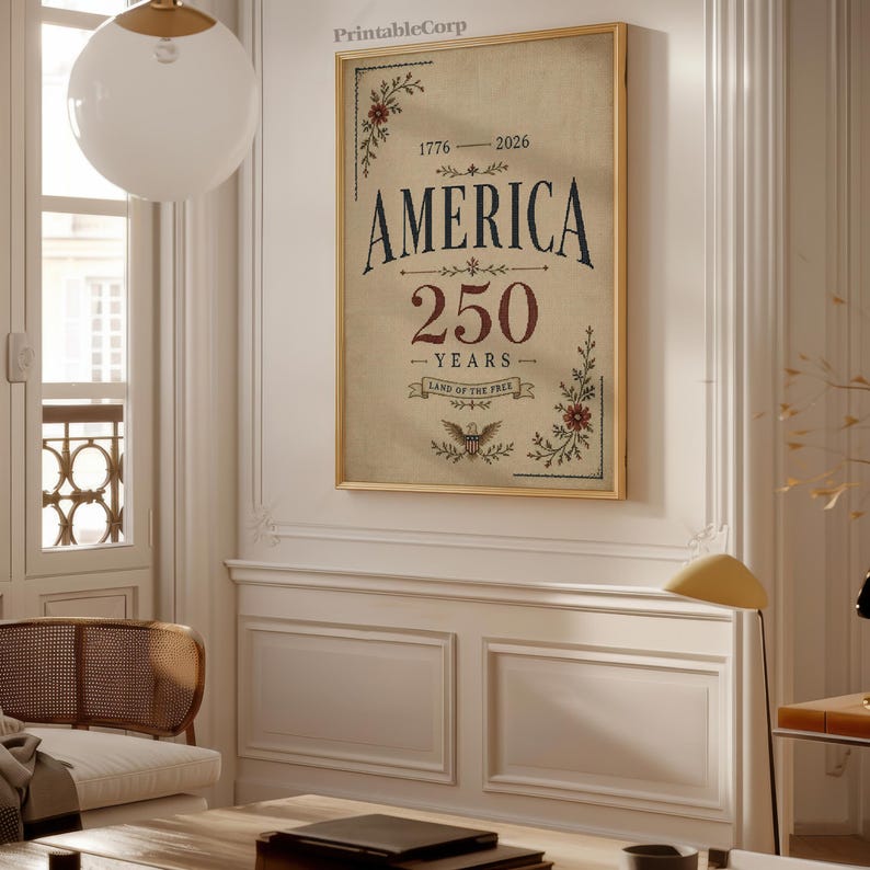 Pu&ograve; includere: Una stampa incorniciata con un design vintage che celebra il 250&deg; anniversario dell'America. L'opera presenta la parola "AMERICA" in grassetto, il numero "250" e la frase "LAND OF THE FREE". Illustrazioni floreali e di aquile adornano gli angoli.
