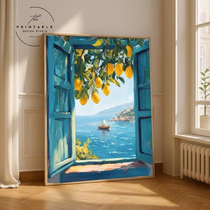 May include: A framed art print showing a coastal scene. The artwork features a blue window framing a view of the sea, a sailboat, and a distant shoreline. Yellow lemons hang from a tree branch. The text "The Printable Design Studio" is in the upper left corner.