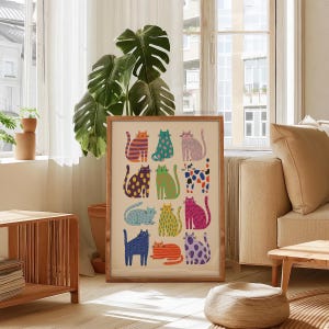 Puede incluir: Un cuadro enmarcado con un patr&oacute;n de gatos estilizados y coloridos. Cada gato tiene un dise&ntilde;o &uacute;nico, con rayas, lunares y varios colores, incluyendo naranja, azul y morado. La obra de arte se exhibe en un sal&oacute;n.