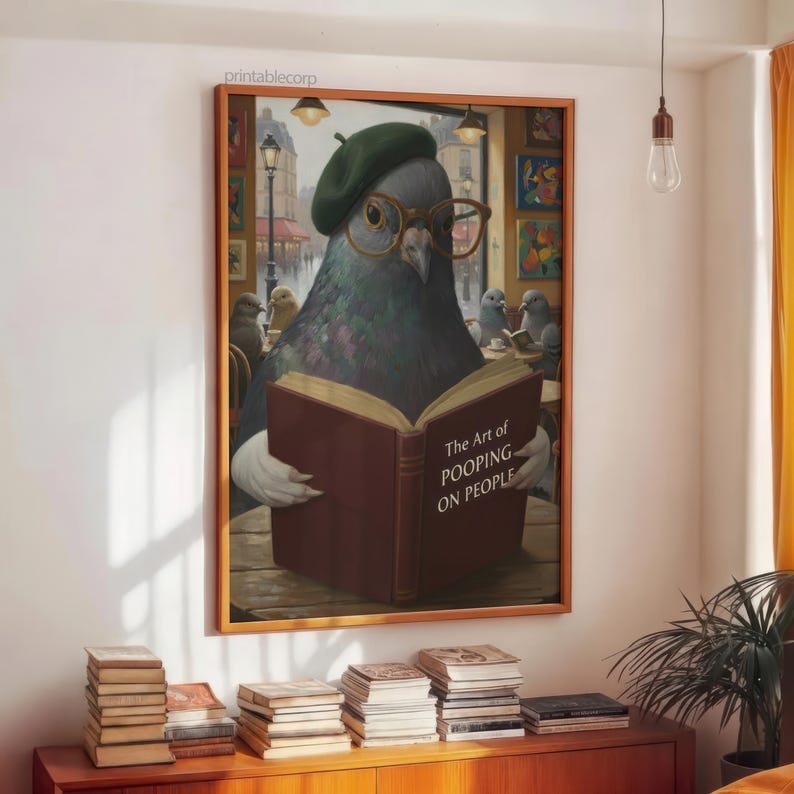 May include: A framed print featuring a pigeon wearing glasses and a beret, reading a book titled "The Art of Pooping on People." The artwork has a humorous theme, with other pigeons in the background. The print is displayed above a wooden cabinet with stacks of books.
