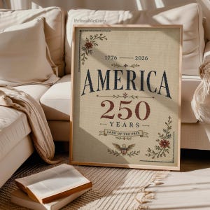 Pu&ograve; includere: Una stampa incorniciata che celebra i 250 anni dell'America. L'opera presenta la parola "AMERICA" in blu navy, con "250 YEARS" in bordeaux. Accenti floreali e un emblema dell'aquila adornano gli angoli e il fondo. La stampa &egrave; su sfondo beige.