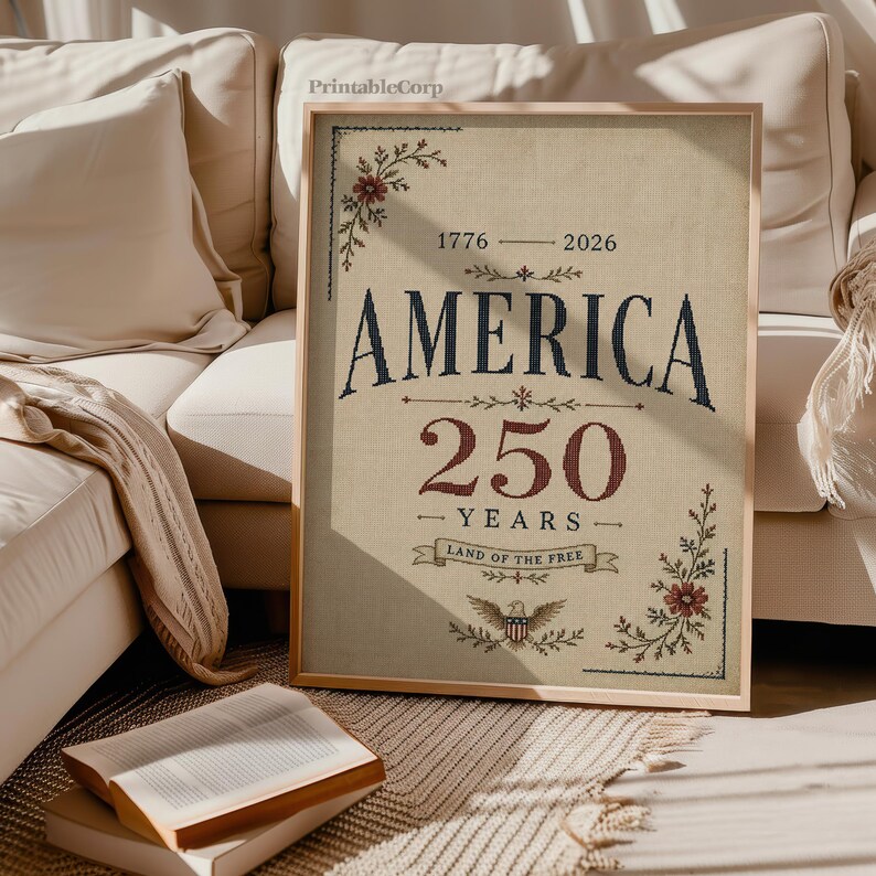 Pu&ograve; includere: Una stampa incorniciata che celebra i 250 anni dell'America. L'opera presenta la parola "AMERICA" in blu navy, con "250 YEARS" in bordeaux. Accenti floreali e un emblema dell'aquila adornano gli angoli e il fondo. La stampa &egrave; su sfondo beige.