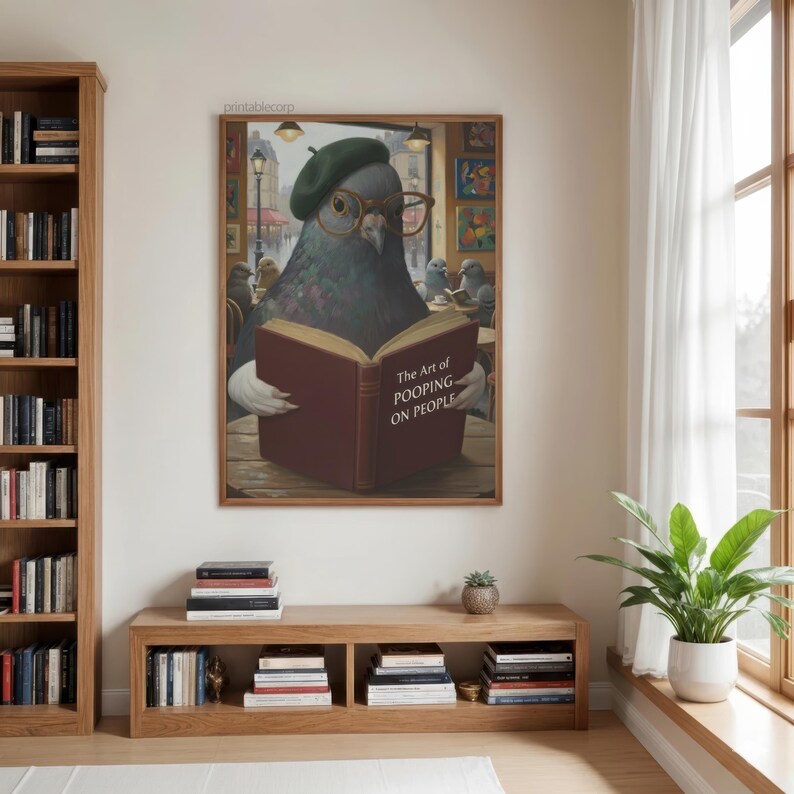 May include: A framed print featuring a pigeon wearing a beret and glasses, reading a book titled "The Art of Pooping on People." The artwork has a humorous theme, with the pigeon in a cafe setting.