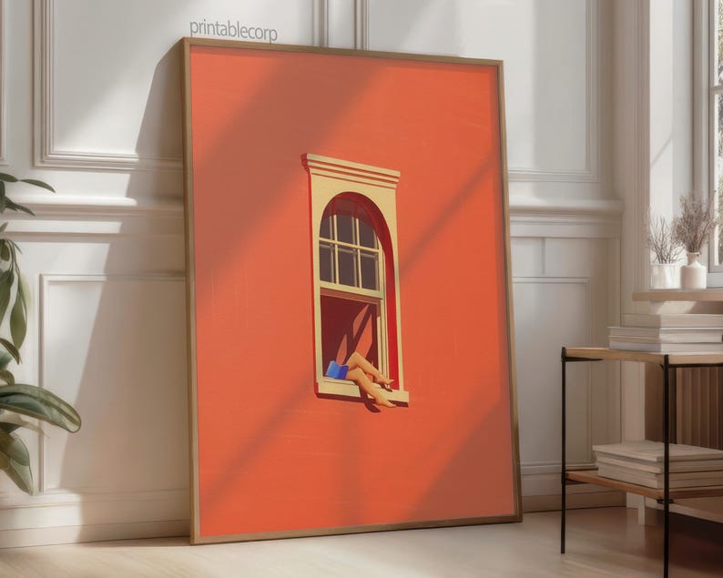 May include: A framed art print featuring a vibrant orange wall with a window. The window has a beige frame and a person's legs are visible, wearing blue shorts. The artwork is leaning against a white wall.