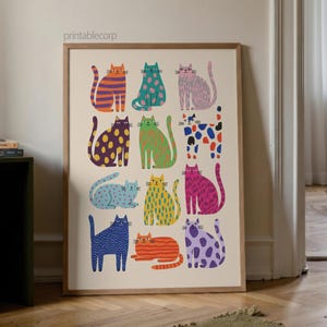Puede incluir: Una impresi&oacute;n art&iacute;stica enmarcada que presenta una colecci&oacute;n de gatos estilizados en varios colores y patrones. Los gatos est&aacute;n representados en naranja, verde, rosa, azul, amarillo y morado, con dise&ntilde;os que incluyen rayas, lunares y colores lisos. La impresi&oacute;n se muestra en una habitaci&oacute;n con suelo de madera.
