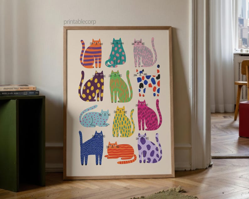 Puede incluir: Una impresi&oacute;n art&iacute;stica enmarcada que presenta una colecci&oacute;n de gatos estilizados en varios colores y patrones. Los gatos est&aacute;n representados en naranja, verde, rosa, azul, amarillo y morado, con dise&ntilde;os que incluyen rayas, lunares y colores lisos. La impresi&oacute;n se muestra en una habitaci&oacute;n con suelo de madera.