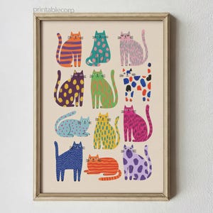 Puede incluir: Una impresi&oacute;n enmarcada con ilustraciones de gatos coloridos y estampados. Los gatos est&aacute;n representados en varias poses y colores, con patrones como lunares y rayas. La impresi&oacute;n tiene un fondo beige y un marco de madera.