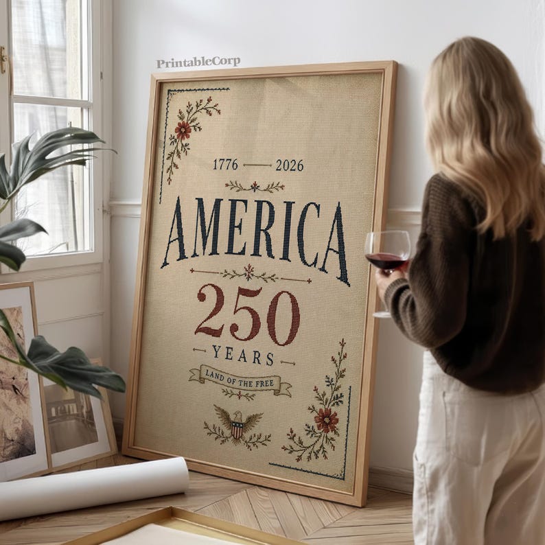 Pu&ograve; includere: Una stampa incorniciata che celebra il 250&deg; anniversario dell'America, con la scritta "AMERICA 250 YEARS" e gli anni 1776-2026. Il design include elementi floreali e un'aquila, su uno sfondo con trama di juta.