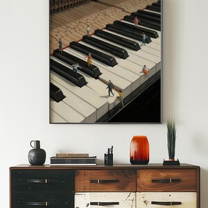 May include: A framed print featuring a surreal image of miniature figures on a grand piano keyboard. The piano keys are black and white, with the text "printablecorp" in the upper left corner. The print is displayed above a wooden dresser.