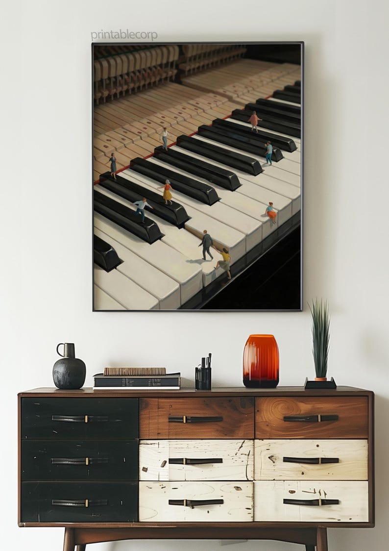 May include: A framed print featuring a surreal image of miniature figures on a grand piano keyboard. The piano keys are black and white, with the text "printablecorp" in the upper left corner. The print is displayed above a wooden dresser.
