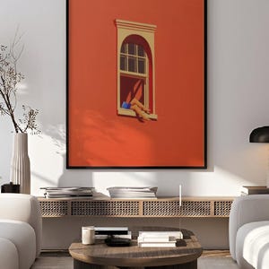 May include: A framed art print featuring a vibrant orange wall with a window. The window has a white frame and a person's legs are visible, with blue shorts. The print is labeled "printablecorp".